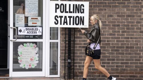 A woman walks past a polling station sign outside Selby Community Centre in Selby North Yorkshire, during voting for the Selby and Ainsty by-election, called following the resignation of incumbent MP Nigel Adams, Thursday July 20, 2023. The polls have opened in three by-elections where defeats would heighten Conservative fears that Rishi Sunak will struggle to lead them to another Commons majority. (Danny Lawson/PA via AP)