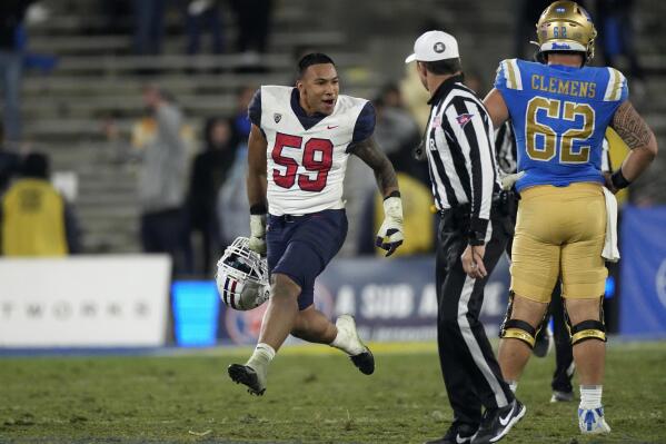 Arizona linebacker Jacob Manu, left, celebrates as UCLA offensive lineman Duke Clemens watches after Arizona defeated UCLA 34-28 in an NCAA college football game Saturday, Nov. 12, 2022, in Pasadena, Calif. (AP Photo/Mark J. Terrill)