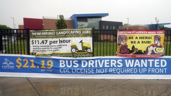 A "Bus Drivers Wanted" sign is shown Wednesday, Aug. 18, 2021, in Sandy, Utah. A shortage of bus drivers is complicating the start of a new school year already facing a surge in COVID-19 cases and conflicts over whether masks should be required in school buildings. (AP Photo/Rick Bowmer)