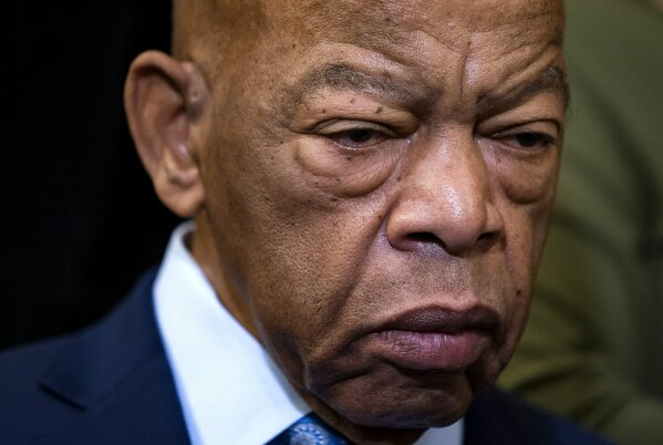 FILE - In this Friday, Dec. 6, 2019, file photo, civil rights leader U.S. Rep. John Lewis, D-Ga., is extolled at an event with fellow Democrats before passing the Voting Rights Advancement Act to eliminate potential state and local voter suppression laws, at the Capitol in Washington. Lewis, who carried the struggle against racial discrimination from Southern battlegrounds of the 1960s to the halls of Congress, died Friday, July 17, 2020. (AP Photo/J. Scott Applewhite, File)