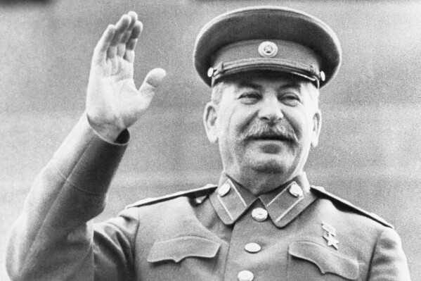 FILE - Soviet leader Josef Stalin raises his right hand in salute while reviewing a May Day Parade in Red Square in Moscow, on May 1, 1946. Abortions were banned under Stalin but became commonplace under later Kremlin leaders. Under President Vladimir Putin, who has forged a has forged a powerful alliance with the Russian Orthodox Church, now promotes 