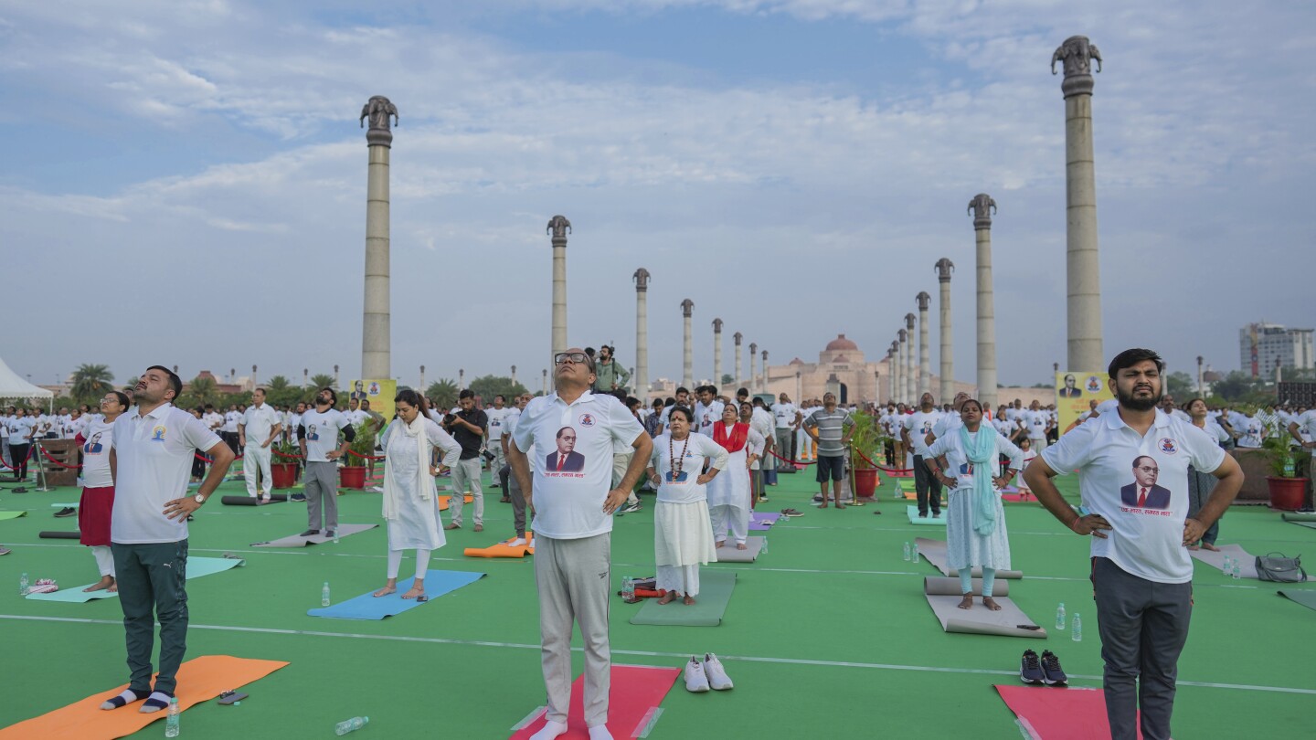 Indians stretch, breathe and balance to mark International Day of Yoga - AP News