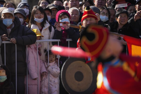 Residents watch Chinese performers dressed in traditional costumes participate in a performance at the Dongyue Temple on the first day of the Chinese Lunar New Year in Beijing, Saturday, Feb. 10, 2024. (AP Photo/Andy Wong)