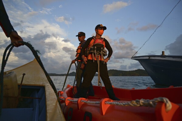 Rescuers stand on a boat during the search for the victims of a capsized Rohingya refugee boat, in Aceh Jaya, Indonesia, Sunday, March 24, 2024. The bodies of a number of Rohingya refugees were found in the sea as the Indonesian authorities ended a search for survivors from a boat that capsized near Aceh province, the provincial search and rescue agency said Sunday. (AP Photo/Reza Saifullah)