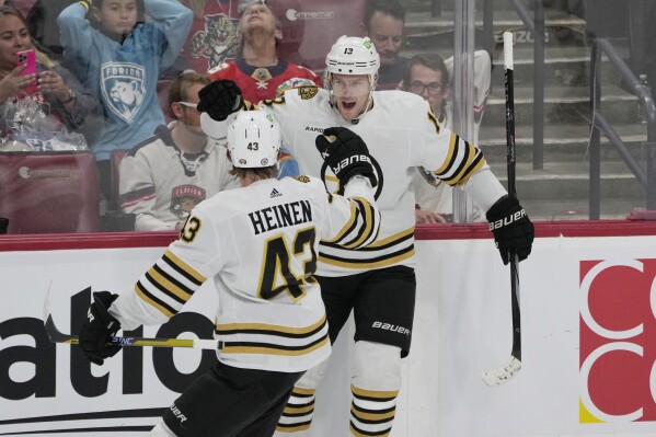 Boston Bruins center Charlie Coyle (13) celebrates his goal with center Danton Heinsen (43) during the first period of an NHL hockey game against the Florida Panthers, Wednesday, Nov. 22, 2023, in Sunrise, Fla. (AP Photo/Marta Lavandier)