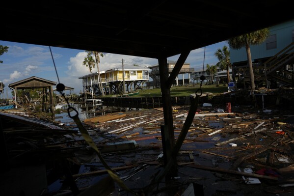 FILE - Debris from destroyed homes and structures float in a canal in Horseshoe Beach, Fla., Aug. 31, 2023, one day after the passage of Hurricane Idalia. Nearly all the experts think 2024 will be one of the busiest Atlantic hurricane seasons on record. (AP Photo/Rebecca Blackwell, File)