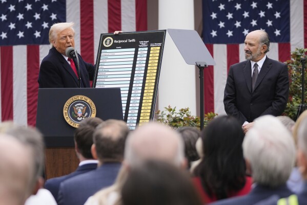 President Donald Trump speaks during an event to announce new tariffs in the Rose Garden at the White House, Wednesday, April 2, 2025, in Washington, as Commerce Secretary Howard Lutnick listens. (AP Photo/Mark Schiefelbein)