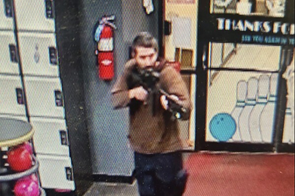 In this image taken from video released by the Androscoggin County Sheriff's Office, an unidentified gunman points a gun while entering Sparetime Recreation in Lewiston, Maine, on Wednesday, Oct. 25, 2023. Maine State Police ordered residents in the state's second-largest city to shelter in place Wednesday night as the suspect remains at large. (Androscoggin County Sheriff's Office via AP)