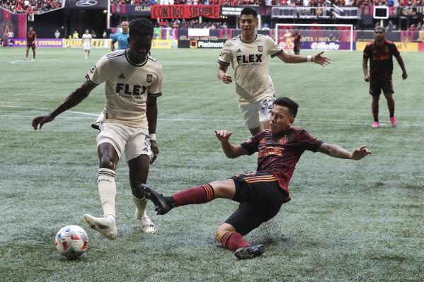 Atlanta United midfielder Ezequiel Barco gets off a shot on goal past Los Angeles FC defender Mamadou Fall that was blocked during the first half of an MLS soccer match, Sunday, Aug. 15, 2021, in Atlanta. (Curtis Compton/Atlanta Journal-Constitution via AP)