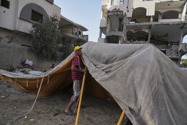 Ne'man Abu Jarad sets up a new tent for his family after they were displaced by the Israeli air and ground offensive in the Gaza Strip in Gaza City, Monday, May 19, 2025. (AP Photo/Jehad Alshrafi)
