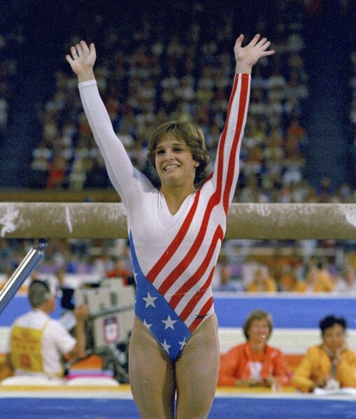 FILE- Mary Lou Retton reacts to applause after her performance at the Summer Olympics in Los Angeles on Aug. 3, 1984. Retton. 55, is in intensive care in a Texas hospital fighting a rare form of pneumonia, according to her daughter McKenna Kelley. (AP Photo/Suzanne Vlamis, File)