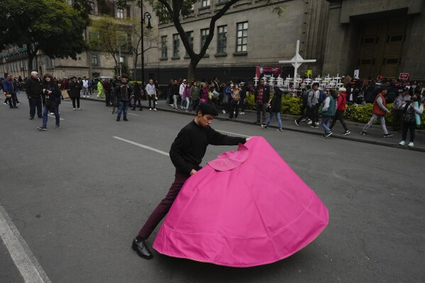 Juan Pablo Vargas makes matador cape movements during a demonstration where supporters and opponents of bullfighting gathered outside the Supreme Court building in Mexico City, Wednesday, Dec. 6, 2023. Mexico's Supreme Court is scheduled to decide whether to reverse a more than yearlong ban on bullfighting. (AP Photo/Fernando Llano)