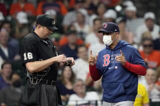 Boston Red Sox manager Alex Cora, right, argues strike calls with home plate umpire Lance Barrett during the sixth inning of a baseball game Thursday, June 3, 2021, in Houston. (AP Photo/David J. Phillip)
