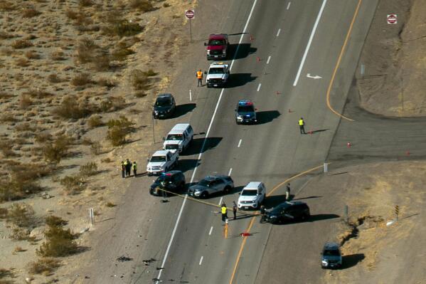 FILE - In this Dec. 10, 2020, file photo, Nevada Highway Patrol investigate the scene of a fatal crash involving multiple bicyclists and a box truck along U.S. Highway 95 southbound near Searchlight, Nev. The Arizona box truck driver who killed five bicyclists on a stretch of Nevada highway last December has been sentenced to at least 16 years in Nevada state prison. Jordan Barson, apologized and sought forgiveness Tuesday, June 8, 2021, during an emotional two-day sentencing hearing in Las Vegas. (L.E. Baskow/Las Vegas Review-Journal via AP, File)
