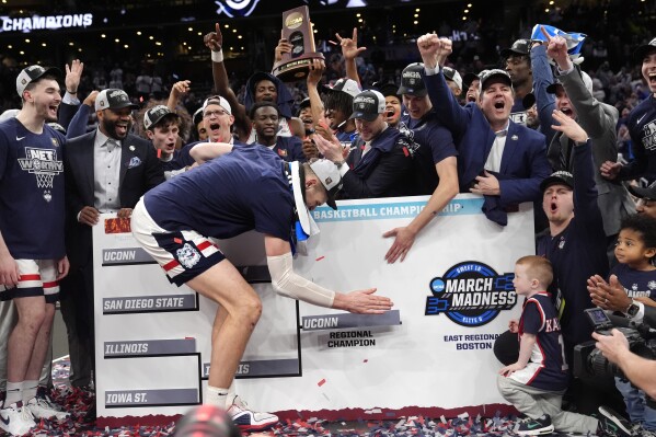 UConn center Donovan Clingan adds his team to the Final Four bracket while celebrating after defeating Illinois in the Elite 8 college basketball game in the men's NCAA Tournament, Saturday, March 30, 2024, in Boston. (AP Photo/Steven Senne)