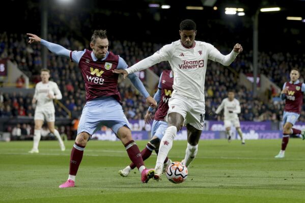 Manchester United's Marcus Rashford, right, and Burnley's Connor Roberts battle for the ball, during the English Premier League soccer match between Burnley and Manchester United at Turf Moor, in Burnley, England, Saturday, Sept. 23, 2023. (Ian Hodgson/PA via AP)