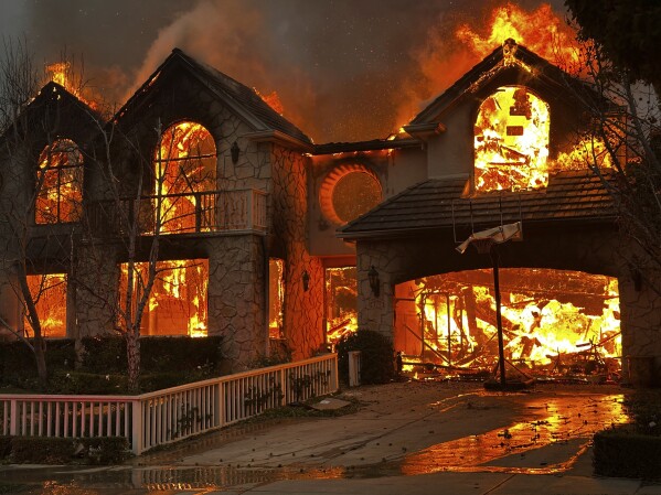 The Palisades Fire burns a structure in the Pacific Palisades neighborhood of Los Angeles, Wednesday, Jan. 8, 2025. (AP Photo/Eugene Garcia)