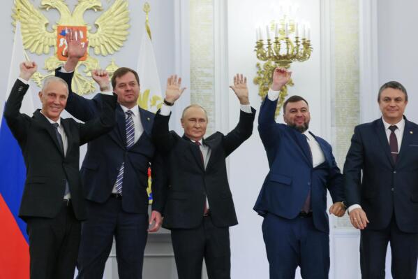 From left, Moscow-appointed head of Kherson Region Vladimir Saldo, Moscow-appointed head of Zaporizhzhia region Yevgeny Balitsky, Russian President Vladimir Putin, center, Denis Pushilin, the leader of the Donetsk People's Republic and Leonid Pasechnik, leader of self-proclaimed Luhansk People's Republic wave during a ceremony to sign the treaties for four regions of Ukraine to join Russia, at the Kremlin, Moscow, Friday, Sept. 30, 2022. The signing of the treaties making the four regions part of Russia follows the completion of the Kremlin-orchestrated "referendums." (Mikhail Metzel, Sputnik, Kremlin Pool Photo via AP)