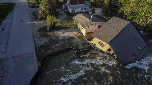 FILE - A house sits in Rock Creek after floodwaters washed away a road and a bridge in Red Lodge, Mont., Wednesday, June 15, 2022. After three nasty years, the La Nina weather phenomenon is gone, the National Oceanic and Atmospheric Administration said Thursday, March 9, 2023. (AP Photo/David Goldman, File)