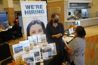 Marriott human resources recruiter Mariela Cuevas, left, talks to Lisbet Oliveros, during a job fair at Hard Rock Stadium, Friday, Sept. 3, 2021, in Miami Gardens, Fla. U.S. employers stepped up their demand for workers in December despite the looming impact of the omicron wave of coronavirus infections. The Labor Department said Tuesday, Feb. 1, 2022, that the number of posted jobs rose 1.4% to 10.9 million on the last day of December, compared with the previous month. (AP Photo/Marta Lavandier)