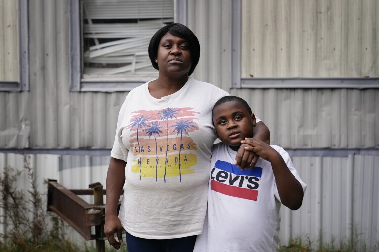 Bontressa Brown, 47, left, and Yuri Brown, 7, right, stand for a portrait outside their home in Sylvester, Ga., on Tuesday, Nov. 14, 2023. “I miss his father daily. He’d have been a great father." (AP Photo/Brynn Anderson)