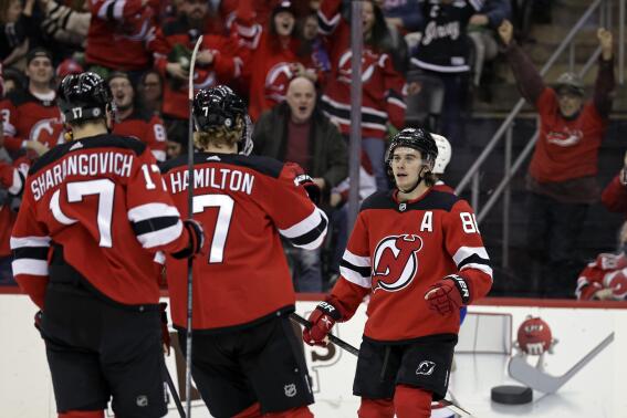 New Jersey Devils center Jack Hughes (86) celebrates with teammates after scoring a goal during the first period of an NHL hockey game against the Montreal Canadiens on Sunday, March 27, 2022, in Newark, N.J. (AP Photo/Adam Hunger)