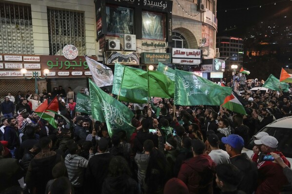 Palestinians wave Hamas flags as they celebrate the Israeli release of Palestinian prisoners in the West Bank city of Nablus, Friday, Nov. 24, 2023. The release came on the first day of a four-day cease-fire deal between Israel and Hamas during which the Gaza militants have pledged to release 50 hostages in exchange for 150 Palestinians imprisoned by Israel. (AP Photo/Majdi Mohammed)