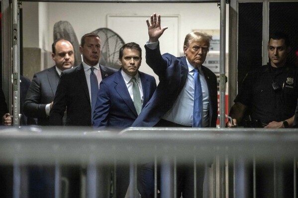 Former President Donald Trump greets the media as he returns from a break during his trial in Manhattan Criminal Court, Friday, April 26, 2024, in New York.  (Dave Sanders/The New York Times via AP, Pool)