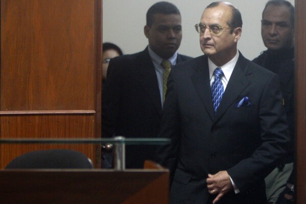 FILE - Peru's former spy chief Vladimiro Montesinos enters the courtroom for a session of former President Alberto Fujimori's trial at a police base in Lima, Peru, June 30, 2008. A Peruvian court on Jan. 31, 2024 sentenced Montesinos, Fujimori's former spy chief, to 19 years and eight months in prison for being the perpetrator of a massacre of six farm workers in 1992. (AP Photo/Martin Mejia, File)