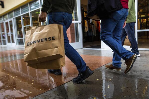 A shopper carries multiple bags while walking with others on Tuesday, March 14, 2023, in Las Vegas. On Wednesday, the Commerce Department releases U.S. retail sales data for February. (AP Photo/Ty O'Neil)