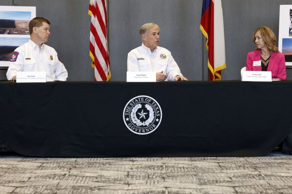 Texas Gov. Greg Abbott, center, speaks alongside Chief Nim Kidd, Texas Division of Emergency Management, left, and Hutchinson County Judge Cindy Irwin during a briefing with local and state officials about the Smokehouse Creek Fire, Friday, March 1, 2024, in Borger, Texas. Wildfires have destroyed as many as 500 structures in the Texas Panhandle, Republican Gov. Greg Abbott said Friday, March 1, 2024 describing how the largest blaze in state history scorched everything in its path, leaving ashes in its wake.