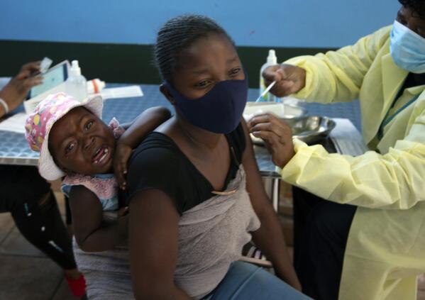 ARCHIVO - Un bebé llora mientras su madre recibe la vacuna de Pfizer contra COVID-19, en el municipio de Diepsloot, cerca de Johannesburgo, el jueves 21 de octubre de 2021. (AP Photo/Denis Farrell, Archivo)