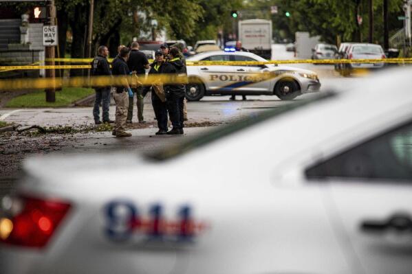 LMPD investigators stand at the corner of Dr. W.J. Hodge and W. Chestnut streets in Louisville's Russell neighborhood after a teenage boy was fatally shot and another wounded in a drive-by shooting at a bus stop Wednesday morning. Sept. 22, 2021. (Jeff Faughender/Courier Journal via AP)