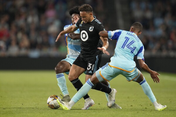 Minnesota United midfielder Hassani Dotson (31) works with the ball between Colorado Rapids midfielder Ralph Priso, left, and forward Calvin Harris (14) during the second half of an MLS soccer match Wednesday, Aug. 30, 2023, in St. Paul, Minn. (AP Photo/Abbie Parr)