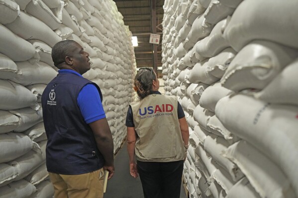 Officials from USAID and WFP inspect a donation of $11 million worth of food aid at a ceremony in Harare, Zimbabwe, Wednesday, Jan 17. 2024. The U.N. World Food Program said Wednesday that it was working with Zimbabwe's government and aid agencies to provide food to 2.7 million rural people in the country as the El Nino weather phenomenon contributes to a drought crisis in southern Africa. (AP Photo/Tsvangirayi Mukwazhi)