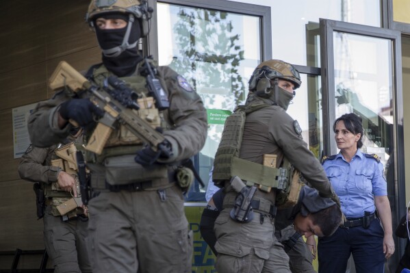 Kosovo police members of Special Intervention Unit escort the arrested Serb gunmen out of the court after the Kosovo shootout in capital Pristina, on Tuesday, Sept. 26, 2023. Sunday's clash was one of the worst since Kosovo declared independence from Serbia in 2008. It came as the European Union and the U.S. are trying to mediate and finalize years long talks on normalizing ties between the two Balkan states. (AP Photo/Visar Kryeziu)