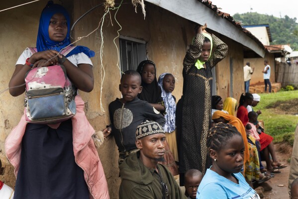 FILE - Residents wait in line to receive the Ebola vaccine in Beni, Congo DRC on July 13, 2019. Internal documents obtained by The Associated Press show that the World Health Organisation has paid $250 each to at least 104 women in Congo who say they were sexually abused or exploited by Ebola outbreak responders. That amount is less than what some U.N. officials are given for a single day's expenses when working in Congo. (AP Photo/Jerome Delay, File)