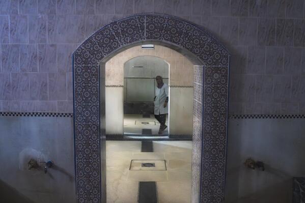 Um trabalhador entra em um banho tradicional marroquino vazio, conhecido como hammam, em Rabat, Marrocos, segunda-feira, 4 de março de 2024. As mudanças climáticas e uma seca que dura há anos forçaram os famosos banhos públicos de Marrocos a fechar alguns dias por semana, em um esforço para salvar água. (AP Photo/Mosa'ab Elshamy)