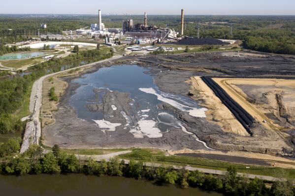 FILE - The Richmond city skyline can be seen on the horizon behind the coal ash ponds along the James River near Dominion Energy's Chesterfield Power Station in Chester, Va., Tuesday, May 1, 2018. The Environmental Protection Agency is moving to strengthen a rule aimed at controlling and cleaning up toxic waste from coal-fired power plants. A proposed rule announced Wednesday, May 17, 2023, would require safe management of so-called coal ash dumped in areas that currently are unregulated at the federal level. (AP Photo/Steve Helber, File)