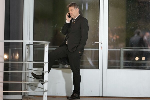 FILE - Robert Habeck, German Vice Chancellor and Federal Minister for Economic Affairs and Climate Action makes a phone call at the chancellery in Berlin, Germany, on Nov. 22, 2023. A group of farmers prevented Germany's vice chancellor disembarking from a ferry hours after the government partially climbed down on cost-saving plans that infuriated the agricultural sector, a protest that drew condemnation from government and opposition figures. (AP Photo/Markus Schreiber)