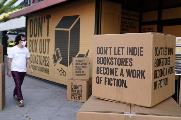 FILE - A pedestrian walks past boxes set up in front of book store Book Soup in West Hollywood, Calif., on Oct. 16, 2020, to encourage shoppers to buy from independent book stores instead of online retailers like Amazon. For independent stores and publishers, the pandemic amplified the divide between the industry's biggest players and everyone else. (AP Photo/Chris Pizzello, File)