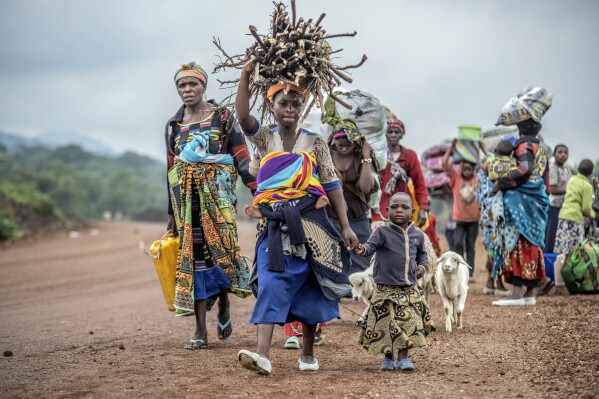 FILE - Residents flee fighting between M23 rebels and Congolese forces near Kibumba, some 20 kms ( 12 miles) North of Goma, Democratic Republic of Congo, on Oct. 29, 2022. Eastern Congo has been beset by conflict for years, with M23 one of more than 100 armed groups vying for a foothold in the mineral-rich area near the border with Rwanda (AP Photo/Moses Sawasawa, File)