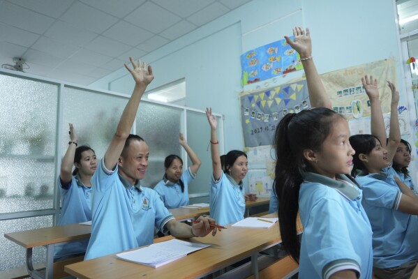 Nguyen Thanh Hai, 34, centre, raises his hand to answer question during class at a school for victims of Agent Orange in Da Nang, Vietnam, March 7, 2025. (AP Photo/Hau Dinh)