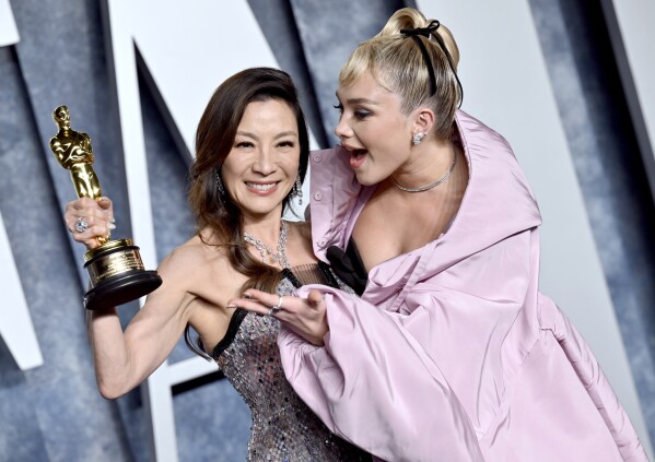 Michelle Yeoh, left, winner of the Oscar for lead actress, and Florence Pugh arrive at the Vanity Fair Oscar Party on Sunday, March 12, 2023, at the Wallis Annenberg Center for the Performing Arts in Beverly Hills, Calif. (Photo by Evan Agostini/Invision/AP)