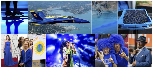This combination of photos shows, top row from left, Blue light projected during the opening ceremony of the ISU World Championships Speed Skating Sprint in the Netherlands, on Feb. 23, 2019, U.S. Navy Blue Angel flying over Sausalito, Calif., on  Oct. 10, 2019, Police firing blue-colored water at protestors in Hong Kong on Aug. 31, 2019, a tray of wild blueberries at the Coastal Blueberry Service in Union, Maine on Aug. 24, 2018, bottom row from left, actress-writer Tina Fey wearing a blue gown at the Oscars on Feb. 24, 2019, Swedish youth climate activist Greta Thunberg, wearing a blue sweatshirt, during a protest outside the White House in Washington on Sept. 13, 2019, H.E.R. performing under blue lights at the Coachella Music & Arts Festival in Indio, Calif. on April 14, 2019, Duke fans wearing blue wigs before an NCAA college basketball game against Florida State in Tallahassee, Fla., on Jan. 12, 2019 and "Today" show co-host Al Roker wearing blue eye glasses on the set in New York on April 5, 2019. The Pantone Color Institute has named Classic Blue as its color of the year for 2020.  (AP Photo)