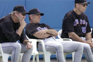 FILE - In this Feb. 25, 2002, file photo, New York Mets manager Bobby Valentine, center, coach Charlie Hough, left, and instructor Tom Robson, right, watch fom behind home plate during an intrasquad game at baseball spring training in Port St. Lucie, Fla. Former major league player and coach Robson has died. He was 75. Robson died of natural causes on Tuesday, April 20, 2021, at Memory Care Facility in Chandler, Ariz., New York Mets spokesman Jay Horwitz said Wednesday. (AP Photo/M. Spencer Green, File)