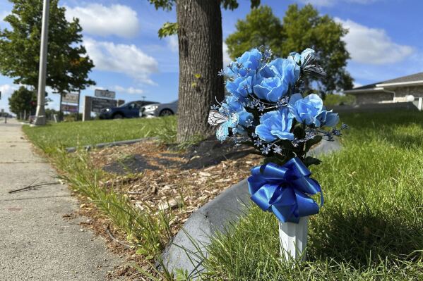 Flowers rest near the scene, Saturday, July 15, 2023, in Fargo, N.D., where one police officer was fatally shot and two others were critically wounded Friday, July 14. Authorities have said the suspect was also killed in the shooting, and a civilian was injured. (AP Photo/Jack Dura).