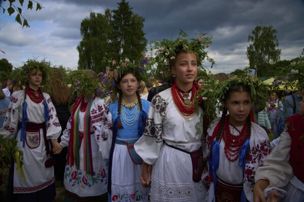 Young women dressed in traditional Ukrainian clothing dance in circle during a traditional midsummer celebration in Pyrohiv, Ukraine, outside of Kyiv, Saturday, June 21, 2025. (AP Photo/Efrem Lukatsky)