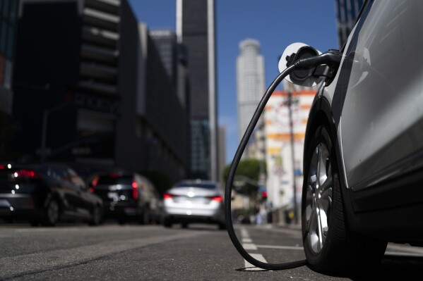 FILE — An electric vehicle is plugged into a charger in Los Angeles, Aug. 25, 2022. Since passage of the Lower Inflation Act, it has strengthened the U.S. transition to renewable energy, accelerated green domestic manufacturing, and made it affordable for consumers to make climate-friendly purchases.  (AP Photo/Jae C. Hong, file)