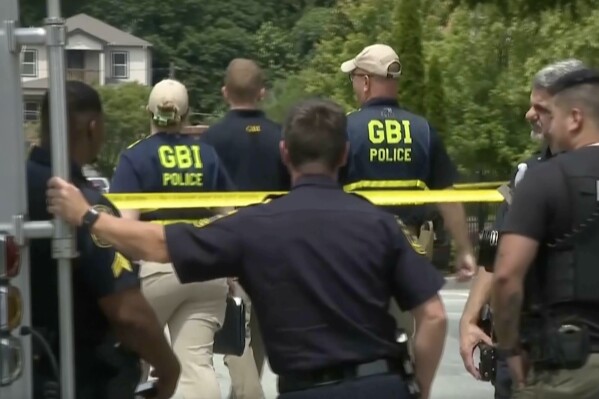 In this image taken from video, police and investigators gather at the scene of a police shooting in Atlanta on Sunday, June 1, 2025. (WSB via AP)